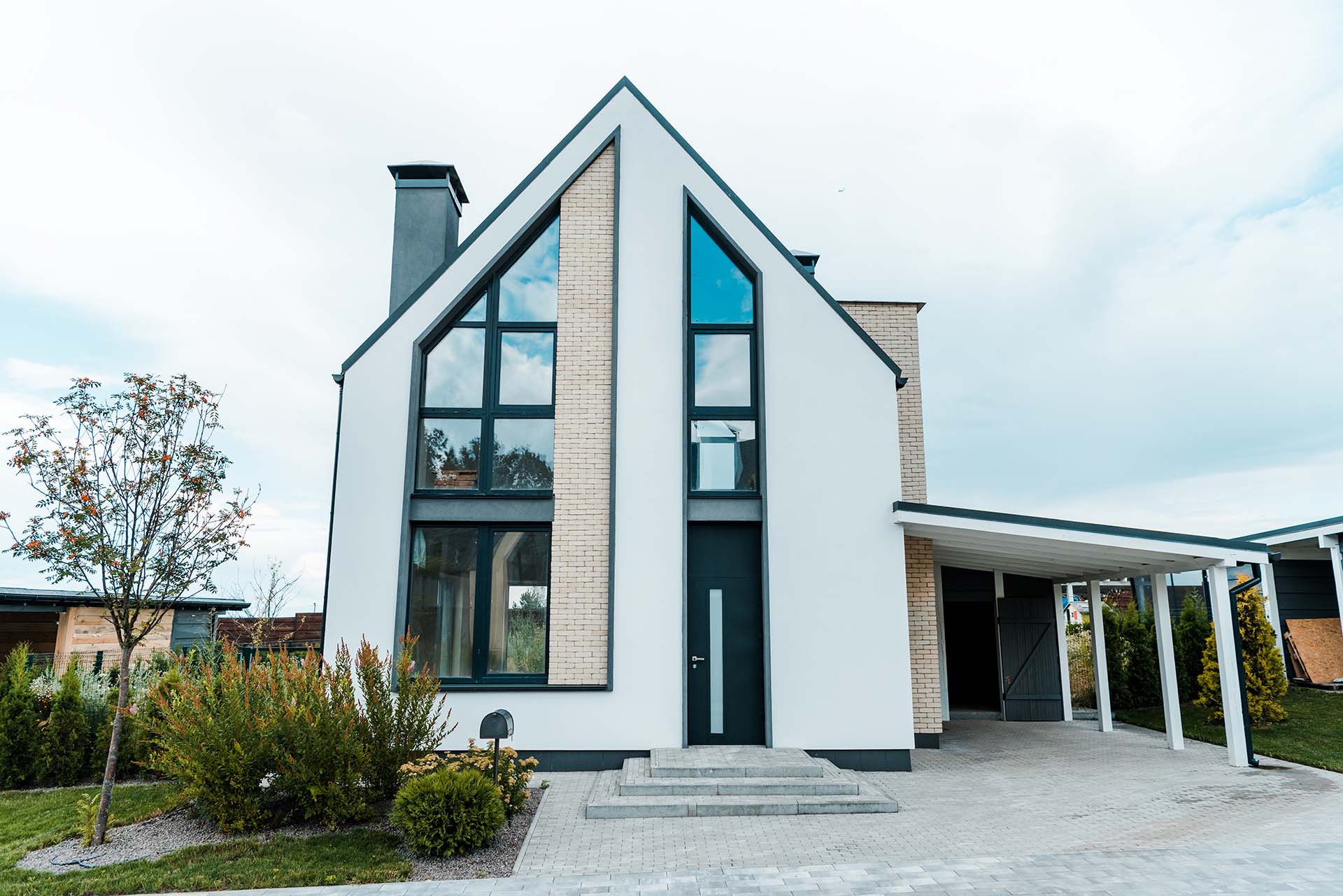 new luxury house near green trees and bushes on grass